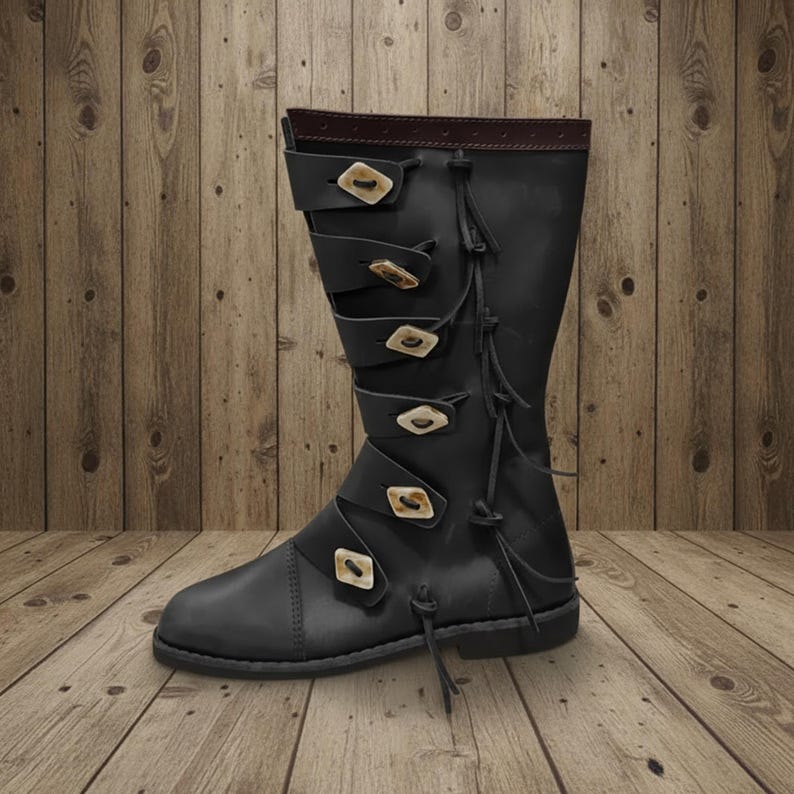 May include: Black leather boot with multiple straps and decorative buckles. The boot has a tall shaft and a rounded toe. The buckles are a light tan color. The boot is approximately 14 inches tall.
