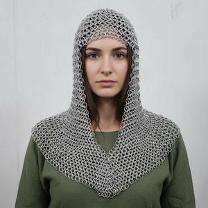 May include: A silver chainmail coif, covering the head and shoulders, with a V-shaped neckline. The coif is made of small, interlocking metal rings. The person in the image is wearing a green shirt.