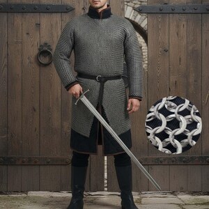 May include: A medieval chainmail shirt with long sleeves and a high collar, worn with a black belt and boots. The shirt is paired with a long sword. A close-up shows the chainmail's intricate metal ring construction.
