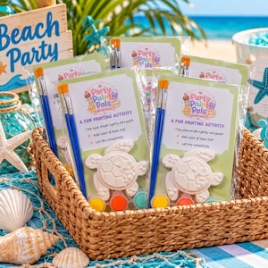 May include: A set of Party Paint Pals turtle painting kits in a woven basket. Each kit includes a white turtle-shaped plaster figure, two blue-handled paintbrushes, and three small paint pots. The packaging features the text A FUN PAINTING ACTIVITY.
