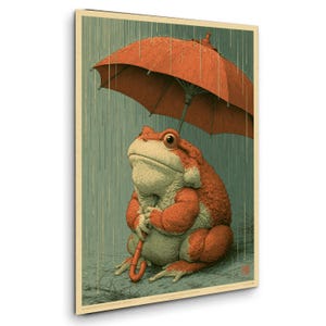 以下が含まれることがあります： 雨の中で座っている、オレンジ色と淡い緑色の質感のあるヒキガエルを描いた長方形のウォールアートプリント。ヒキガエルは頭の上に鮮やかなオレンジ色の大きな傘をさしています。背景は落ち着いた青緑色で、垂直の線が入っています。