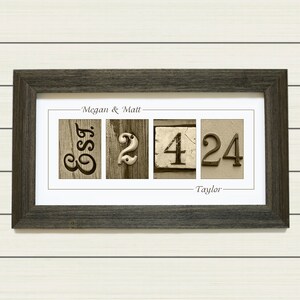 May include: A framed print with the names "Megan & Matt" and "Taylor" and the numbers "32424" in a rustic style.