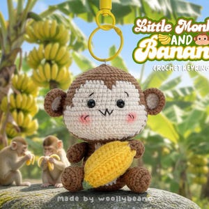 Peut inclure: Porte-clés en crochet représentant un singe tenant une banane jaune. Le singe est fait de fil marron et blanc, avec des joues roses et un visage souriant. Le porte-clés porte l'inscription "Little Monkey and Banana" et "Crochet Keyring".