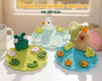May include: Crochet animal coasters in green, blue, and yellow. The coasters feature a frog, duck, and seal design. The text "Crochet animals coasters PDF PATTERN" is displayed at the top of the image. The coasters are handmade and placed on a white surface.