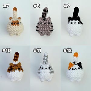 Pu&ograve; includere: Sei peluche di gatto all'uncinetto etichettati da #7 a #12. Ognuno presenta un corpo rotondo, piccole orecchie, una coda verticale e occhi a perla neri. I gatti variano nei motivi di colore, tra cui crema, grigio tigrato, bianco e nero, marrone e bianco.