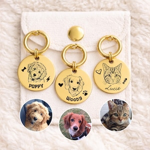 Peut inclure: Trois médailles d'identification pour animaux de compagnie en métal doré circulaire, chacune gravée d'un portrait personnalisé de chien ou de chat. Les médailles portent les noms Poppy, Woody et Lucie, avec des icônes de cœurs, d'os et de pattes.