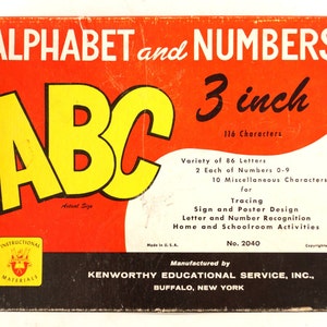Puede incluir: Una caja roja con el texto "ALPHABET and NUMBERS 3 inch 116 Characters" y un gran "ABC" amarillo en el centro. La caja es para un conjunto de herramientas de aprendizaje de alfabeto y números de 7,6 cm. La caja también incluye el texto "Variety of 86 Letters 2 Each of Numbers 0-9 10 Miscellaneous Characters for Tracing Sign and Poster Design Letter and Number Recognition Home and Schoolroom Activities Made in U.S.A. No. 2040 Copyrighted 1953 Manufactured by KENWORTHY EDUCATIONAL SERVICE, INC., BUFFALO, NEW YORK."