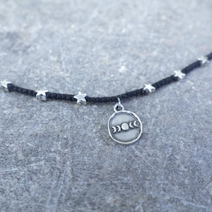 Può includere: Una tazza di ceramica bianca con manico nero e la scritta "But First, Coffee" in grassetto nero. La tazza è posta su uno sfondo sfocato, evidenziando il suo design semplice.