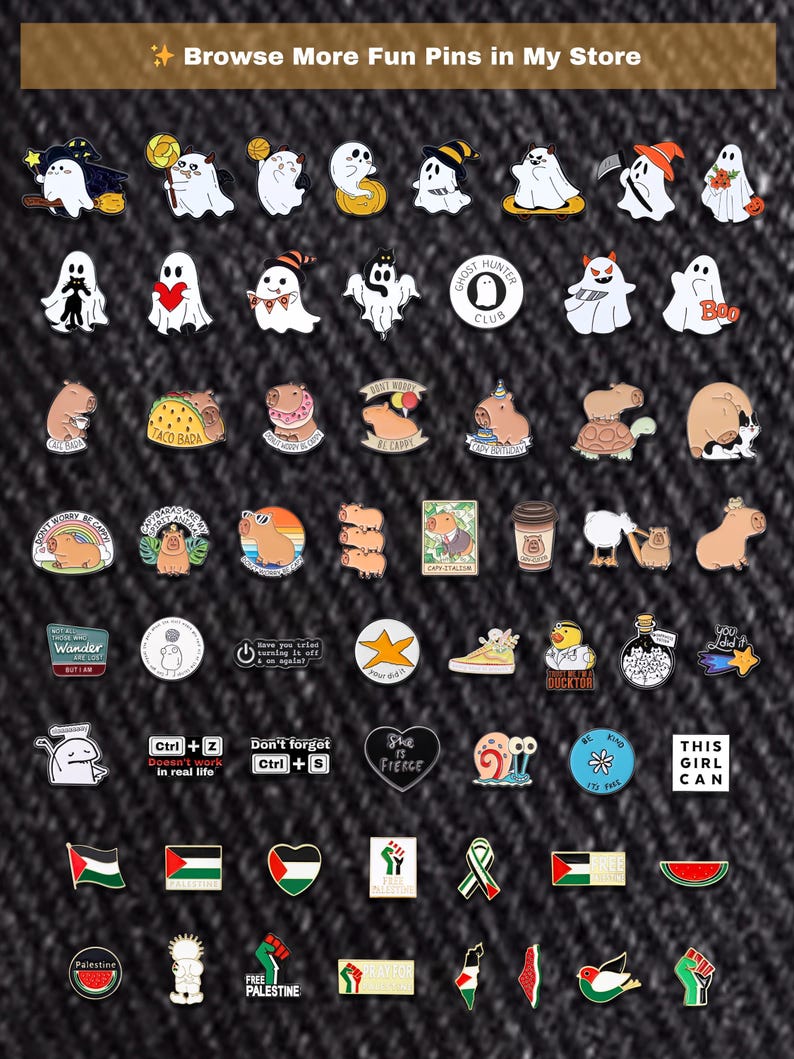 May include: A selection of enamel pins with diverse designs, such as ghosts, capybaras, and motivational phrases. Some pins display text like "Ghost Hunter Club," "Taco Bada," and "This Girl Can." The pins are set against a dark denim background.