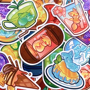 May include: A collection of colorful stickers featuring cute cartoon animals and food items. Designs include a green tea cup with bubbles, a drink with a flower, and a dessert with a blue animal. The stickers are in various shapes and sizes.