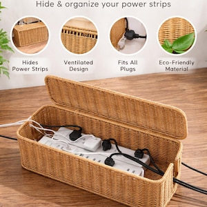 May include: A natural rattan cable management box with an open lid, concealing a power strip and cords. The box is designed to hide and organise power strips. The text on the image says "Natural Rattan Cable Management Box".