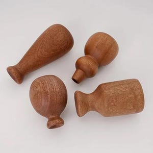 May include: Four wooden objects in various shapes, including a rounded top, a bulbous shape, and a cylindrical form. The objects are a warm brown color, with visible wood grain, and appear to be handmade. The objects are likely decorative or functional items.