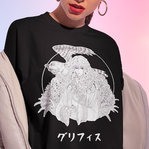 Könnte beinhalten: Schwarzes T-Shirt mit einer schwarz-weißen Illustration eines Charakters mit Vogel- und Blumenelementen in einem weißen Kreis. Japanischer Text darunter.
