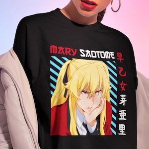 May include: Black t-shirt featuring a graphic of a blonde anime character with the text "MARY SAOTOME" in red and Japanese characters. The character is wearing a red blazer and white shirt. The shirt is black.
