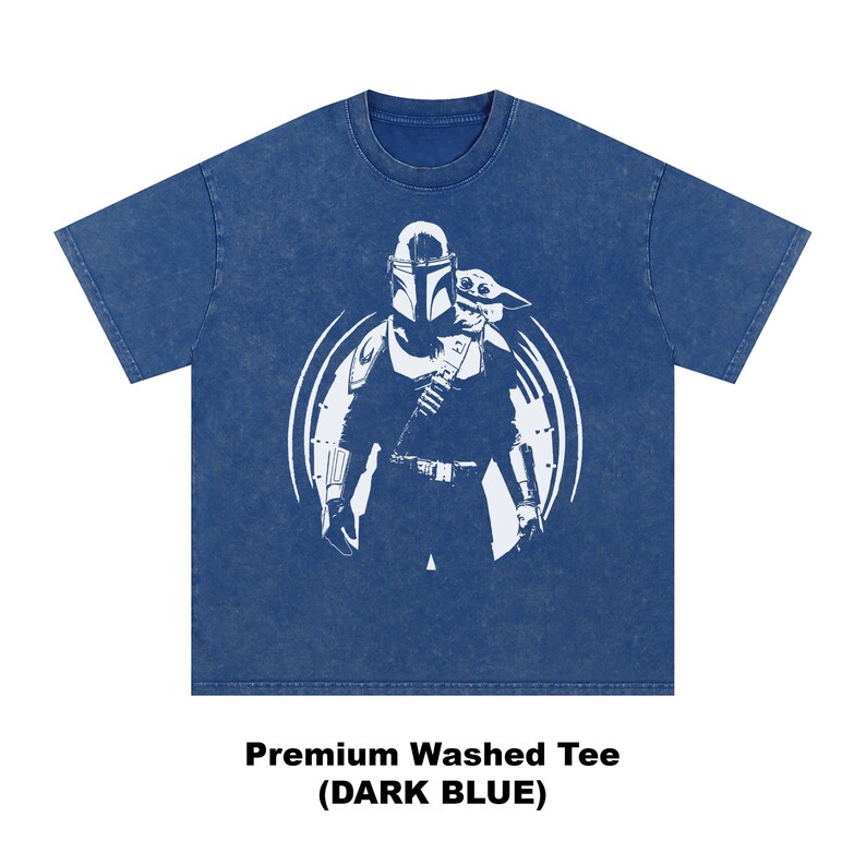 May include: Dark blue premium washed tee with a white graphic of a character in armour holding a child. The design is within a white circle. The text "Premium Washed Tee (DARK BLUE)" is below the graphic.