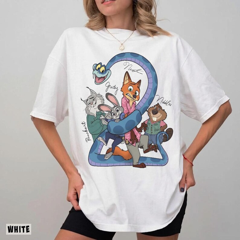 May include: White t-shirt featuring a cartoon graphic of characters from a movie. The design includes a blue snake forming the number "2" with the names "Judy", "Nick", "Nibbles", and "Paubert" written on it.