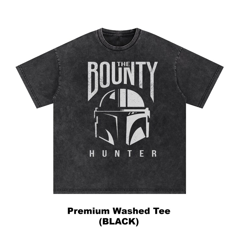 Puede incluir: Camiseta negra lavada de primera calidad con un gr&aacute;fico blanco de un casco y las palabras "THE BOUNTY HUNTER". La camiseta tiene cuello redondo y mangas cortas. El texto "Premium Washed Tee (BLACK)" est&aacute; en la parte inferior.