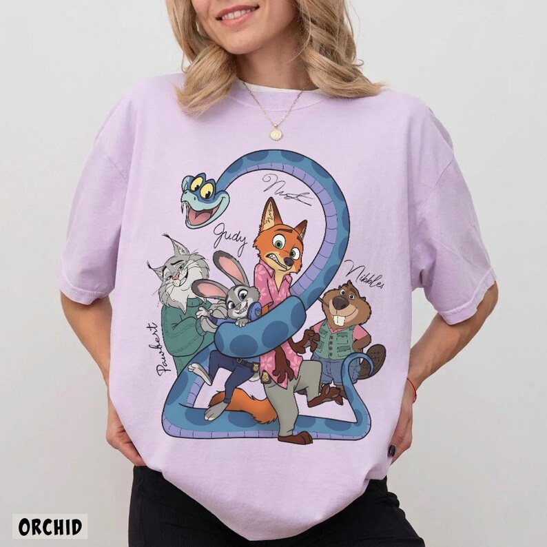 May include: A light purple t-shirt featuring a cartoon graphic of characters from the movie Zootopia. The graphic includes a blue snake forming the number 2, with the names of the characters written on the snake. The word "ORCHID" is printed at the bottom.