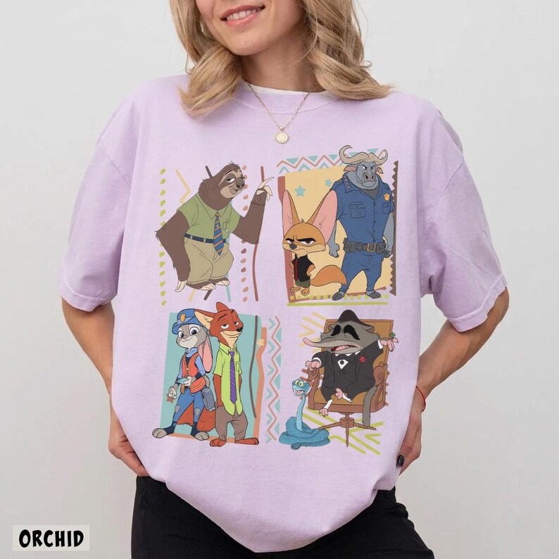 Puede incluir: Camiseta lila claro con un gr&aacute;fico de dibujos animados colorido de personajes de Zootopia. La palabra "ORCHID" est&aacute; impresa en la parte inferior. La camiseta tiene mangas cortas y cuello redondo.
