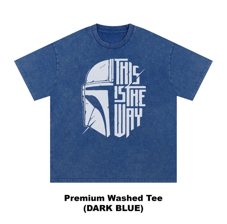 May include: Dark blue t-shirt featuring a white helmet graphic and the text "THIS IS THE WAY". A premium washed tee.