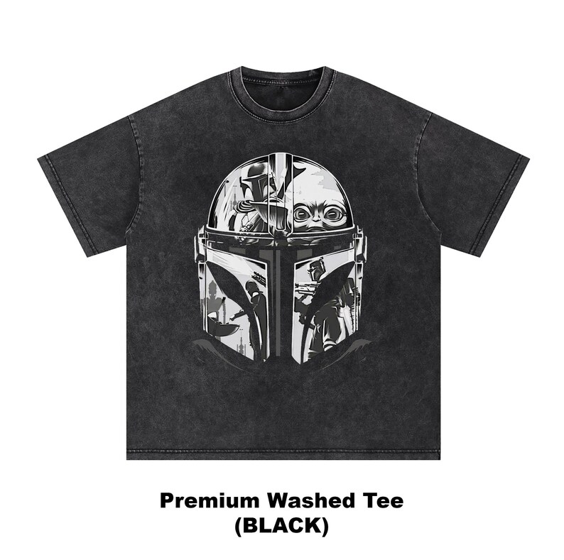 May include: Dark grey washed tee with a graphic of a helmet and a baby's face. The text "Premium Washed Tee (BLACK)" is at the bottom. The shirt is a dark grey colour.