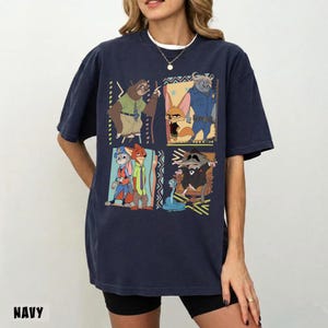 Puede incluir: Camiseta azul marino con un gr&aacute;fico colorido de personajes de una popular pel&iacute;cula animada. El dise&ntilde;o incluye cuatro paneles con diferentes personajes. La palabra "NAVY" est&aacute; impresa en la parte inferior de la camiseta.