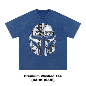 May include: Dark blue t-shirt with a black and white graphic of a Mandalorian helmet and Baby Yoda. The shirt has short sleeves and a crew neck. The text at the bottom of the shirt reads "Premium Washed Tee (DARK BLUE)".