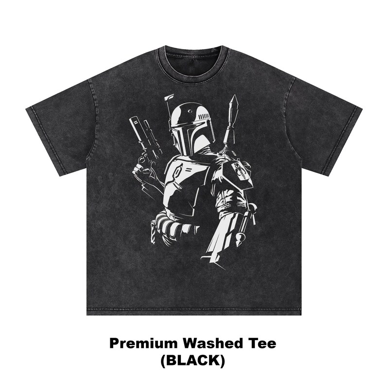 May include: Black washed tee featuring a white graphic of a helmeted character holding a blaster and a spear. The text "Premium Washed Tee (BLACK)" is printed at the bottom of the shirt. The tee has a crew neck and short sleeves.
