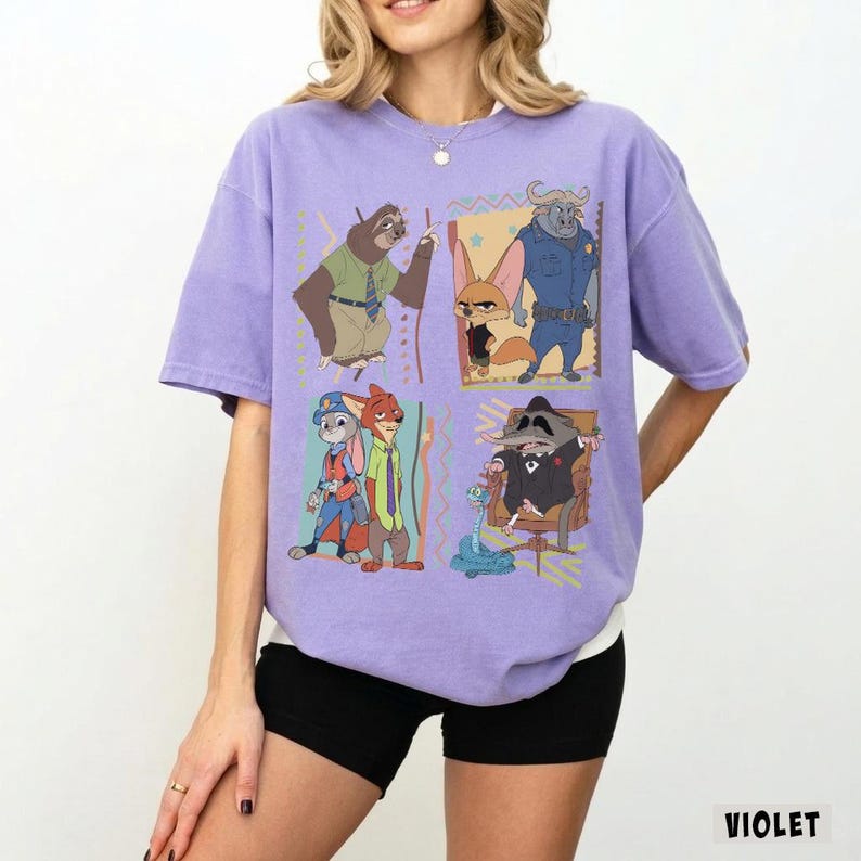 Puede incluir: Camiseta violeta con personajes de dibujos animados en cuatro paneles. Los personajes incluyen un perezoso, un zorro, un toro, un mapache, un conejo y un zorro. La palabra "VIOLET" est&aacute; impresa en blanco en la esquina inferior derecha.