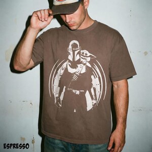 May include: Espresso-coloured t-shirt with a white graphic of The Mandalorian and Grogu from Star Wars. The design is set within a circular frame. The word "ESPRESSO" is printed at the bottom of the image.