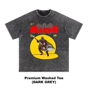 May include: Dark grey premium washed tee featuring a comic book style illustration of The Mandalorian with Grogu. The word "MANDO" is in large red letters, with the text "No. 9" and "10&cent;" above the illustration. The shirt's text reads "Premium Washed Tee (DARK GREY)".