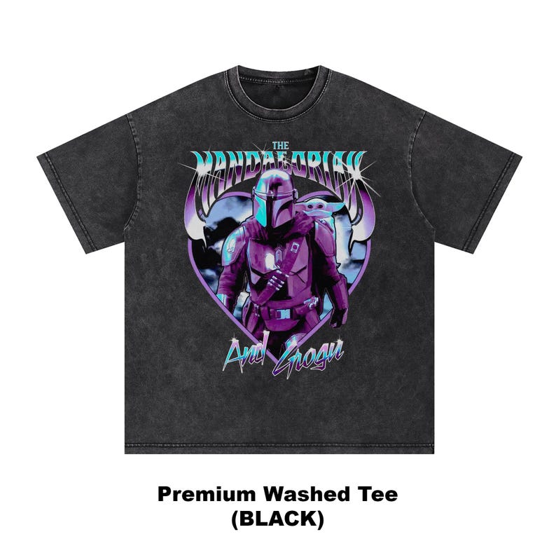 May include: Black washed tee featuring a graphic of The Mandalorian and Grogu in a heart-shaped design. The design includes the text "The Mandalorian" and "And Grogu" in a stylized font. The shirt is labeled "Premium Washed Tee (BLACK)".