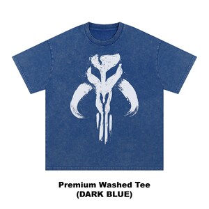 May include: Dark blue washed tee shirt featuring a white graphic design. The graphic is a stylized, abstract symbol. The shirt has short sleeves and a crew neck. The text at the bottom of the image reads "Premium Washed Tee (DARK BLUE)".