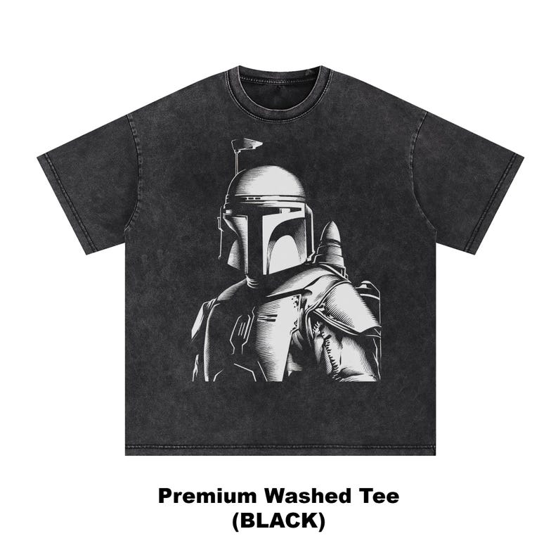 K&ouml;nnte beinhalten: Schwarz gewaschenes T-Shirt mit einer wei&szlig;en Illustration eines behelmten Charakters. Die Grafik ist detailliert und stilisiert. Der Text "Premium Washed Tee (BLACK)" ist unten auf dem T-Shirt aufgedruckt.