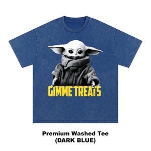 Op de afbeelding: Donkerblauwe premium gewassen T-shirt met een zwart-wit afbeelding van een personage met grote oren en de tekst "GIMME TREATS" in het geel. Het shirt heeft een ronde hals.