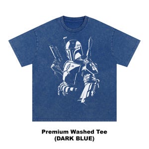 May include: Dark blue premium washed tee featuring a white graphic of a character with a helmet, holding a blaster and a spear. The text "Premium Washed Tee (DARK BLUE)" is at the bottom of the image.