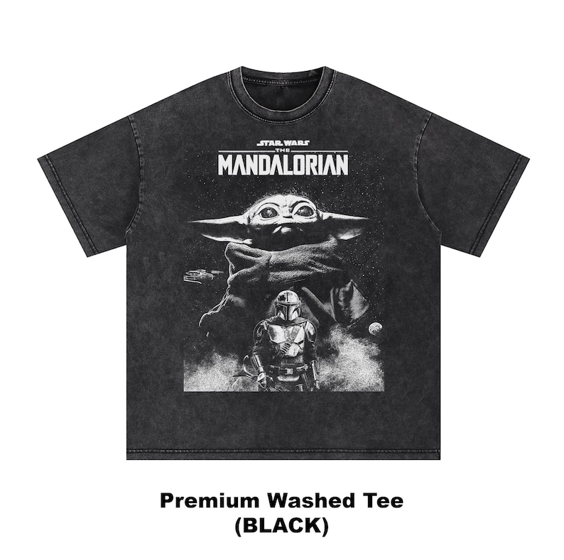 May include: Black washed tee featuring a graphic of The Mandalorian and Grogu from Star Wars. The design includes the text "STAR WARS THE MANDALORIAN" above the characters. The shirt is labeled "Premium Washed Tee (BLACK)".