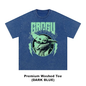 May include: Dark blue premium washed tee featuring a graphic of Grogu, with the word "GROGU" in green above the image. The image of Grogu is in a circle with green lightning bolts on either side. The shirt is dark blue.