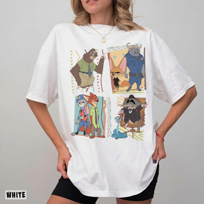 Puede incluir: Camiseta blanca con un dise&ntilde;o de dibujos animados colorido con personajes de Zootopia. El dise&ntilde;o incluye cuatro paneles con diferentes personajes. La palabra "WHITE" est&aacute; impresa en la parte inferior izquierda de la camiseta.