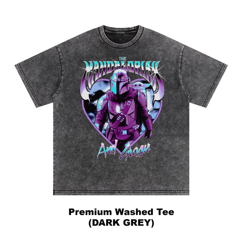 May include: Dark grey premium washed tee featuring a graphic of The Mandalorian and Grogu in purple and blue. The design is set against a heart-shaped background. The text "The Mandalorian" and "And Grogu" are also visible.