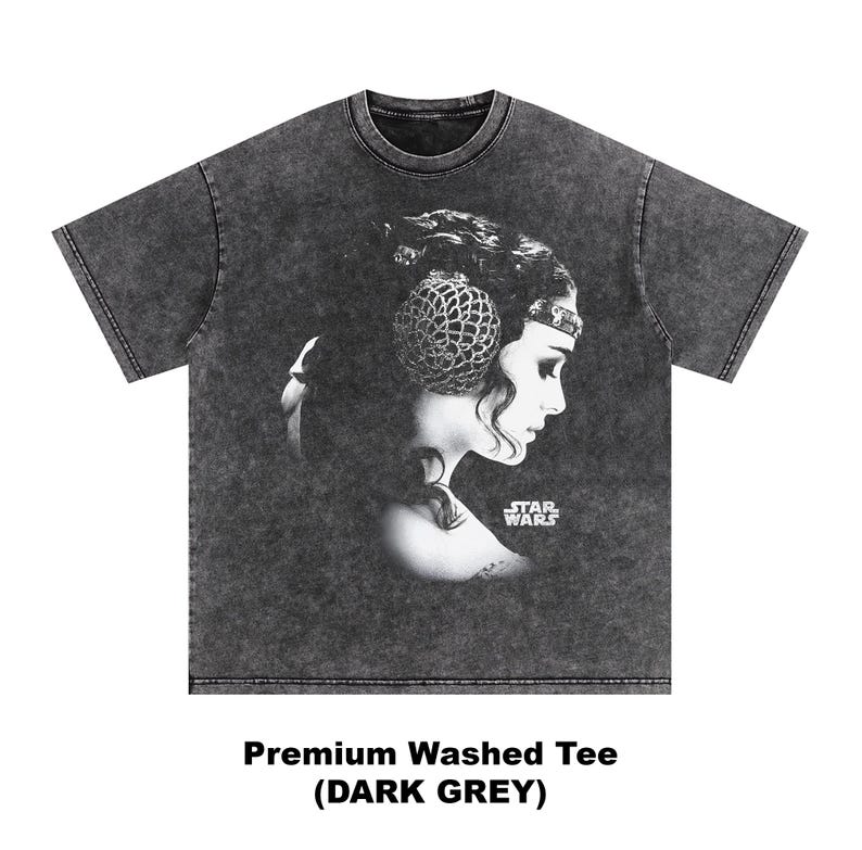 May include: Dark grey t-shirt featuring a black and white portrait of a woman with a headpiece, with the Star Wars logo. The shirt has the text "Premium Washed Tee (DARK GREY)".