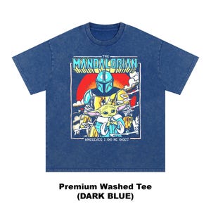 May include: Dark blue premium washed tee featuring a graphic of The Mandalorian and Grogu. The design includes the text "THE MANDALORIAN" and "WHEREVER I GO HE GOES!" in a retro style. The shirt is dark blue.