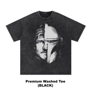 May include: Black washed tee featuring a split face design. One half of the design is a man's face with a mustache, and the other half is a helmet. The text "Premium Washed Tee (BLACK)" is at the bottom of the shirt.