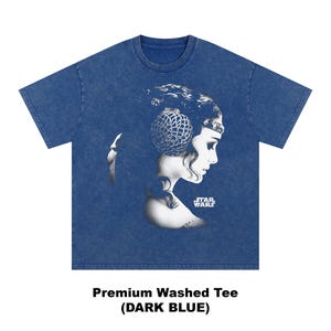 May include: Dark blue t-shirt featuring a black and white graphic of a woman's profile with a decorative headpiece. The Star Wars logo is visible. The text "Premium Washed Tee (DARK BLUE)" is printed at the bottom.