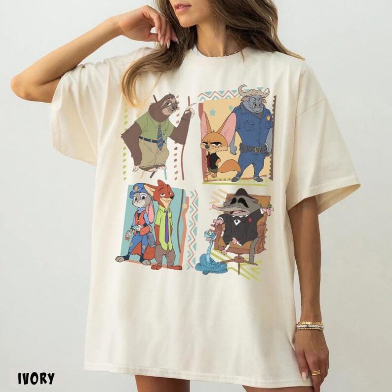 Puede incluir: Camiseta de color marfil con personajes de dibujos animados en cuatro paneles cuadrados. Los personajes incluyen un perezoso, un zorro, un toro, un conejo y un mapache. La palabra "IVORY" est&aacute; impresa en la parte inferior de la camiseta.