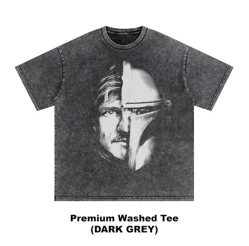 May include: Dark grey washed tee featuring a split face design of a man and a Mandalorian helmet. The graphic is in black and white. The text at the bottom reads "Premium Washed Tee (DARK GREY)".