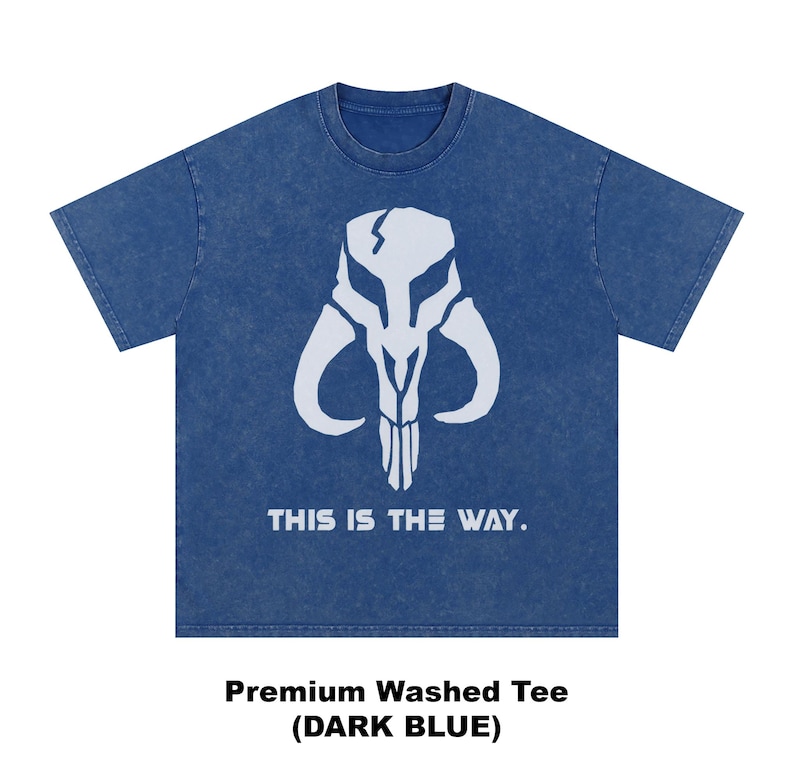 May include: Dark blue t-shirt featuring a white Mandalorian skull design. The text "THIS IS THE WAY" is printed below the graphic. The shirt is a premium washed tee.