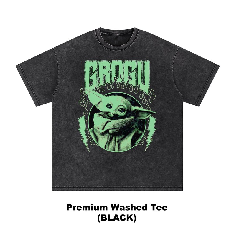 May include: Black washed tee featuring a green graphic of Grogu with the word "GROGU" above. The design includes lightning bolts and flames. The shirt is labeled "Premium Washed Tee (BLACK)".