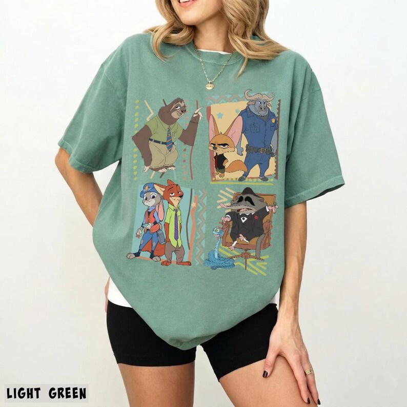 Puede incluir: Camiseta verde claro con un gr&aacute;fico colorido de personajes de una popular pel&iacute;cula animada. El dise&ntilde;o incluye un perezoso, un zorro, un b&uacute;falo, un conejo y un mapache. La camiseta es de material suave y tiene mangas cortas.