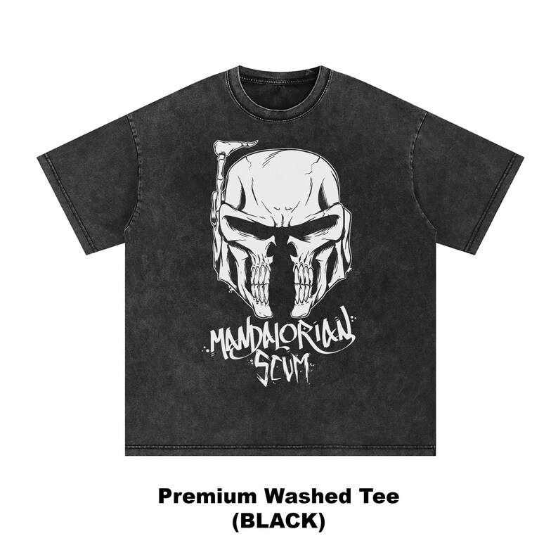 Pu&ograve; includere: T-shirt nera lavata con una grafica bianca di un casco a forma di teschio e la scritta "Mandalorian Scum". La maglietta &egrave; una t-shirt lavata di alta qualit&agrave;. Il testo "Premium Washed Tee (BLACK)" &egrave; in basso nell'immagine.